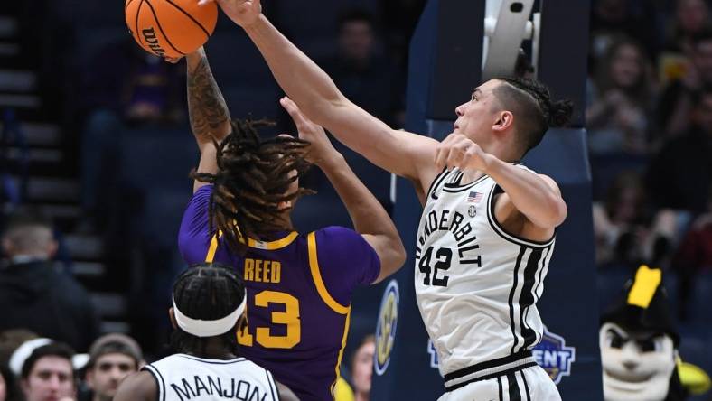 Mar 9, 2023; Nashville, TN, USA; Vanderbilt Commodores forward Quentin Millora-Brown (42) blocks a shot attempt by LSU Tigers forward Jalen Reed (13) during the first half at Bridgestone Arena. Mandatory Credit: Christopher Hanewinckel-USA TODAY Sports