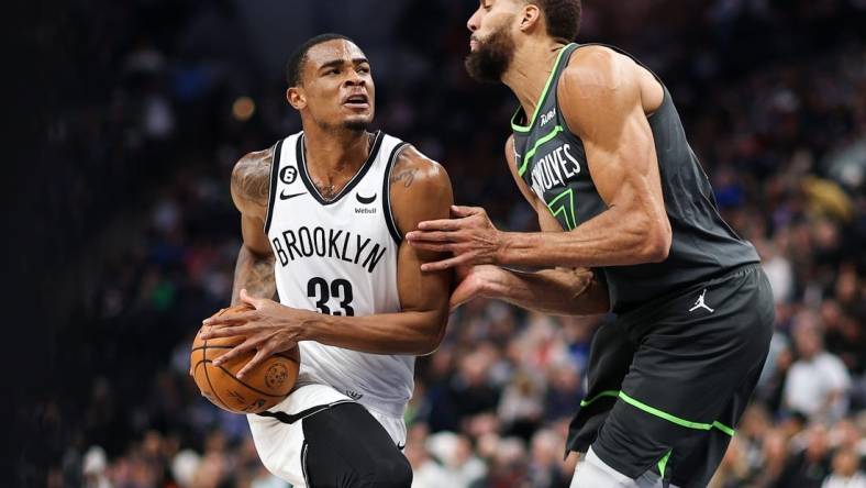 Mar 10, 2023; Minneapolis, Minnesota, USA; Brooklyn Nets center Nic Claxton (33) drives while Minnesota Timberwolves center Rudy Gobert (27) defends during the second quarter at Target Center. Mandatory Credit: Matt Krohn-USA TODAY Sports