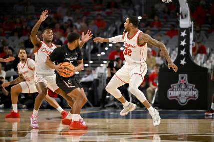 Mar 11, 2023; Fort Worth, TX, USA; Houston Cougars guard Marcus Sasser (0) and forward Reggie Chaney (32) defend against Cincinnati Bearcats guard David DeJulius (5) during the first half at Dickies Arena. Mandatory Credit: Jerome Miron-USA TODAY Sports