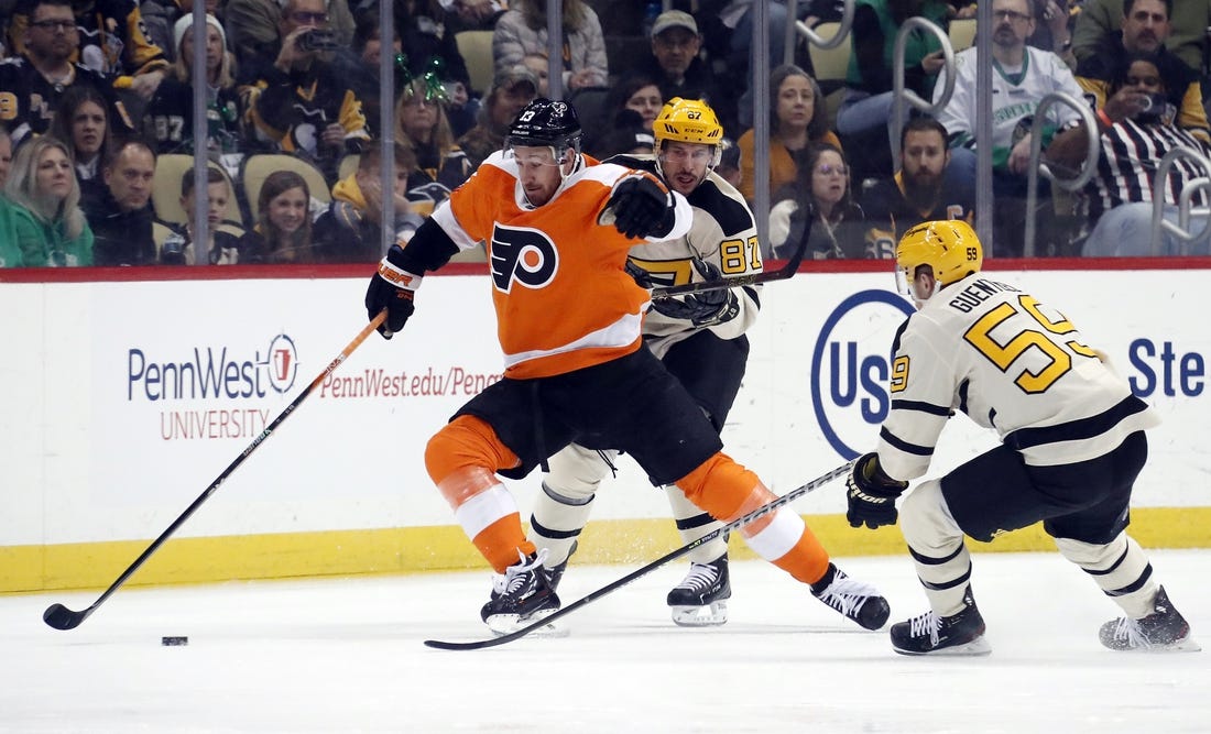 Mar 11, 2023; Pittsburgh, Pennsylvania, USA;  Philadelphia Flyers center Kevin Hayes (13) reaches for the puck against Pittsburgh Penguins center Sidney Crosby (87) and left wing Jake Guentzel (59) during the first period at PPG Paints Arena. Mandatory Credit: Charles LeClaire-USA TODAY Sports