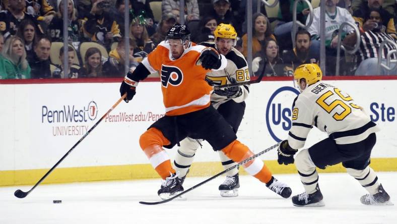 Mar 11, 2023; Pittsburgh, Pennsylvania, USA;  Philadelphia Flyers center Kevin Hayes (13) reaches for the puck against Pittsburgh Penguins center Sidney Crosby (87) and left wing Jake Guentzel (59) during the first period at PPG Paints Arena. Mandatory Credit: Charles LeClaire-USA TODAY Sports