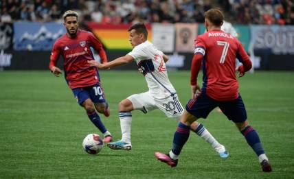 Mar 11, 2023; Vancouver, British Columbia, CAN; Vancouver Whitecaps midfielder Andres Cubas (20) dribbles the ball against FC Dallas forward Jesus Ferreira (10) during the first half at BC Place. Mandatory Credit: Anne-Marie Sorvin-USA TODAY Sports