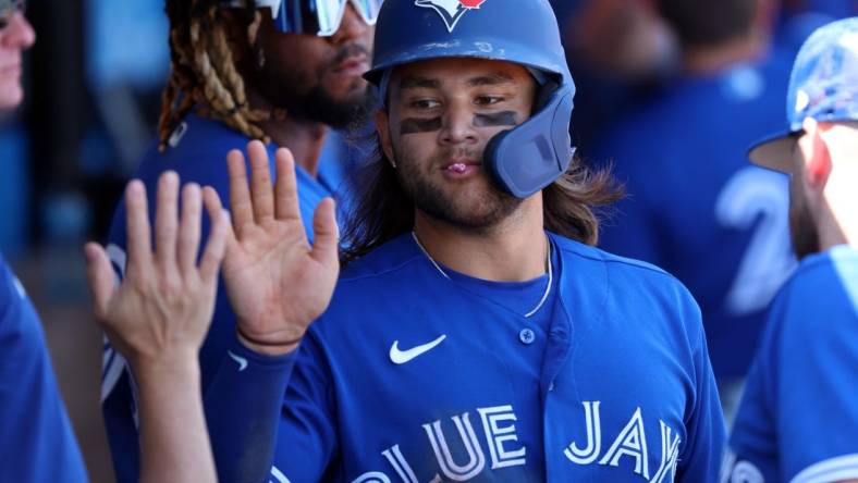 Mar 12, 2023; Clearwater, Florida, USA; Toronto Blue Jays shortstop Bo Bichette (11) scores a run against the Philadelphia Phillies during the fourth inning at BayCare Ballpark. Mandatory Credit: Kim Klement-USA TODAY Sports