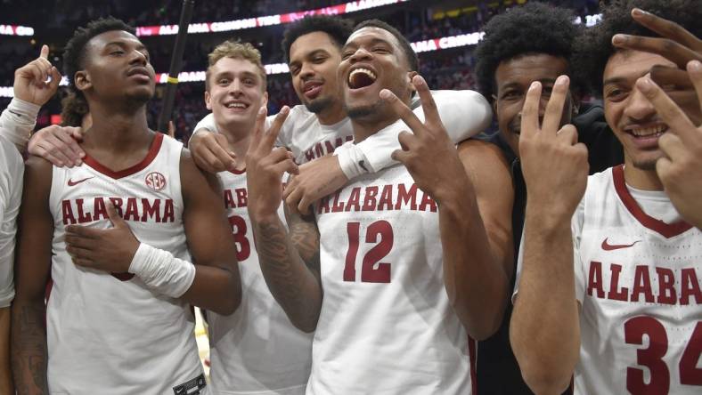 Mar 12, 2023; Nashville, TN, USA;  Alabama Crimson Tide guard Jaden Bradley (0), center Charles Bediako (14), guard Jahvon Quinerly (5), guard Adam Cottrell (30), guard Delaney Heard (12), and guard Rylan Griffen (3) celebrate the win against the Texas A&M Aggies during the second half at Bridgestone Arena. Mandatory Credit: Steve Roberts-USA TODAY Sports