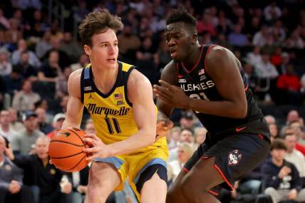 Mar 10, 2023; New York, NY, USA; Marquette Golden Eagles guard Tyler Kolek (11) controls the ball against Connecticut Huskies forward Adama Sanogo (21) during the second half at Madison Square Garden. Mandatory Credit: Brad Penner-USA TODAY Sports