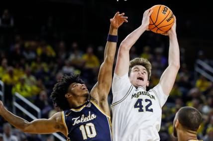 Michigan forward Will Tschetter (42) grabs a rebound against Toledo guard RayJ Dennis (10) during the first half of the first round of the NIT at Crisler Center in Ann Arbor on Tuesday, March 14, 2023.
