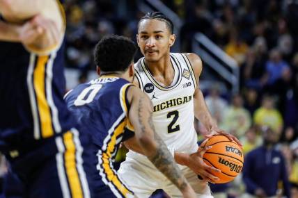 Michigan guard Kobe Bufkin (2) looks to pass against Toledo guard Ra'Heim Moss (0) during the second half of the first round of the NIT at Crisler Center in Ann Arbor on Tuesday, March 14, 2023.