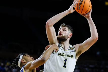 Michigan center Hunter Dickinson (1) goes to the basket against Toledo guard Dante Maddox Jr. (21) during the second half of the first round of the NIT at Crisler Center in Ann Arbor on Tuesday, March 14, 2023.