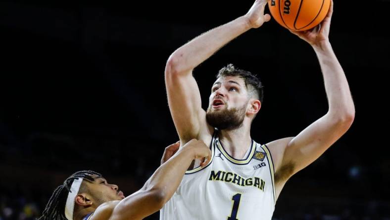 Michigan center Hunter Dickinson (1) goes to the basket against Toledo guard Dante Maddox Jr. (21) during the second half of the first round of the NIT at Crisler Center in Ann Arbor on Tuesday, March 14, 2023.