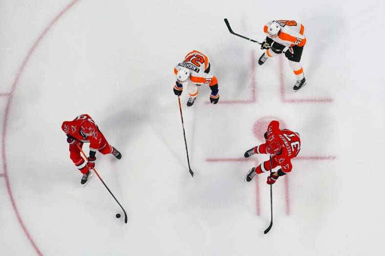 Mar 9, 2023; Raleigh, North Carolina, USA;  Carolina Hurricanes center Sebastian Aho (20) with right wing Andrei Svechnikov (37) against Philadelphia Flyers center Scott Laughton (21) and defenseman Justin Braun (61) during the third period at PNC Arena. Mandatory Credit: James Guillory-USA TODAY Sports