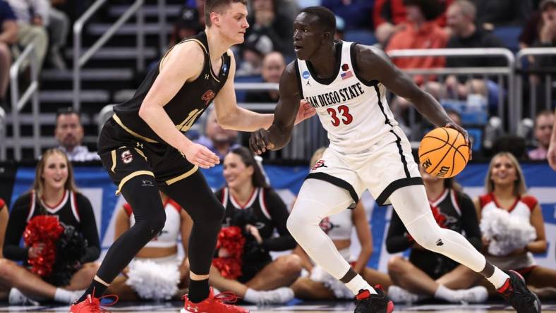 Mar 16, 2023; Orlando, FL, USA; San Diego State Aztecs forward Aguek Arop (33) dribbles the ball while defended by College of Charleston Cougars forward Ante Brzovic (10) during the second half at Amway Center. Mandatory Credit: Matt Pendleton-USA TODAY Sports