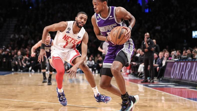 Mar 16, 2023; Brooklyn, New York, USA;  Sacramento Kings guard De'Aaron Fox (5) looks to drive past Brooklyn Nets forward Mikal Bridges (1) in the second quarter at Barclays Center. Mandatory Credit: Wendell Cruz-USA TODAY Sports