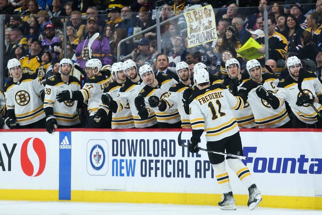 Mar 16, 2023; Winnipeg, Manitoba, CAN;  Boston Bruins forward Trent Frederic (11) is congratulated by his teammates after scoring against the Winnipeg Jets during the first period at Canada Life Centre. Mandatory Credit: Terrence Lee-USA TODAY Sports