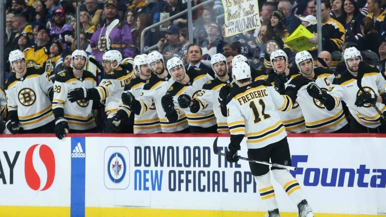 Mar 16, 2023; Winnipeg, Manitoba, CAN;  Boston Bruins forward Trent Frederic (11) is congratulated by his teammates after scoring against the Winnipeg Jets during the first period at Canada Life Centre. Mandatory Credit: Terrence Lee-USA TODAY Sports