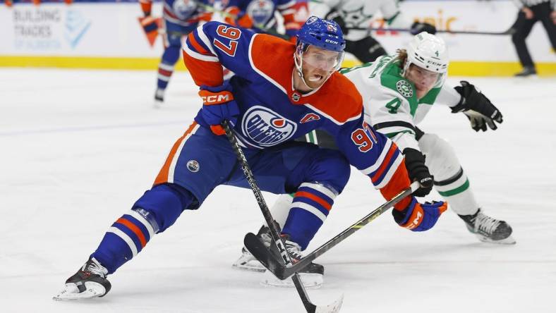 Mar 16, 2023; Edmonton, Alberta, CAN;Edmonton Oilers forward Connor McDavid (97) carries the puck around Dallas Stars defensemen Miro Heiskanen (4) during the first period at Rogers Place. Mandatory Credit: Perry Nelson-USA TODAY Sports