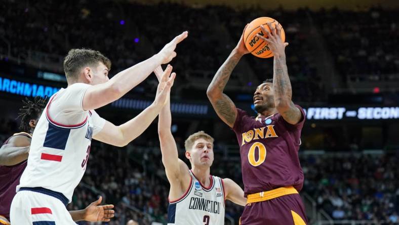 Mar 17, 2023; Albany, NY, USA; Iona Gaels guard Berrick JeanLouis (0) drives to the basket against UConn Huskies center Donovan Clingan (32) and guard Joey Calcaterra (3) during the first half at MVP Arena. Mandatory Credit: David Butler II-USA TODAY Sports