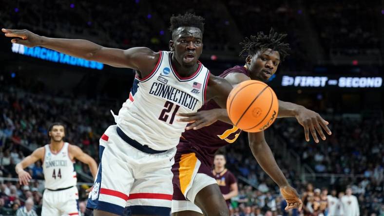 Mar 17, 2023; Albany, NY, USA; Iona Gaels forward Nelly Junior Joseph (13) reaches for the ball against UConn Huskies forward Adama Sanogo (21) during the first half at MVP Arena. Mandatory Credit: David Butler II-USA TODAY Sports