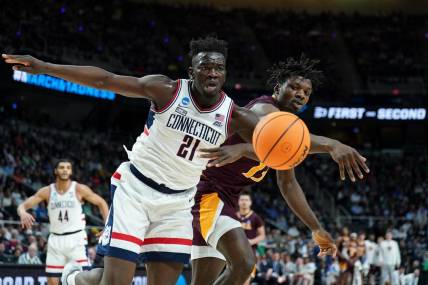 Mar 17, 2023; Albany, NY, USA; Iona Gaels forward Nelly Junior Joseph (13) reaches for the ball against UConn Huskies forward Adama Sanogo (21) during the first half at MVP Arena. Mandatory Credit: David Butler II-USA TODAY Sports