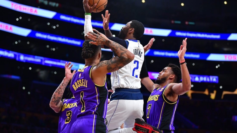 Mar 17, 2023; Los Angeles, California, USA; Dallas Mavericks guard Kyrie Irving (2) shoots against Los Angeles Lakers forward Anthony Davis (3) guard D'Angelo Russell (1) and forward Troy Brown Jr. (7) during the first half at Crypto.com Arena. Mandatory Credit: Gary A. Vasquez-USA TODAY Sports