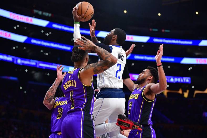 Mar 17, 2023; Los Angeles, California, USA; Dallas Mavericks guard Kyrie Irving (2) shoots against Los Angeles Lakers forward Anthony Davis (3) guard D'Angelo Russell (1) and forward Troy Brown Jr. (7) during the first half at Crypto.com Arena. Mandatory Credit: Gary A. Vasquez-USA TODAY Sports