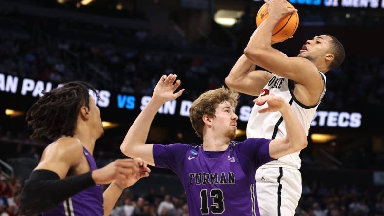 Mar 18, 2023; Orlando, FL, USA;  San Diego State Aztecs forward Jaedon LeDee (13) pulls down a rebound against Furman Paladins forward Garrett Hien (13) during the first half in the second round of the 2023 NCAA Tournament at Legacy Arena. Mandatory Credit: Matt Pendleton-USA TODAY Sports