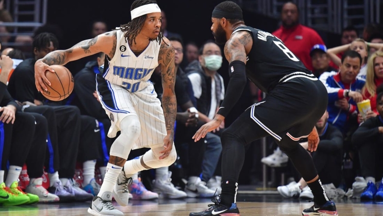 Mar 18, 2023; Los Angeles, California, USA; Orlando Magic guard Markelle Fultz (20) controls the ball against Los Angeles Clippers forward Marcus Morris Sr. (8) during the first half at Crypto.com Arena. Mandatory Credit: Gary A. Vasquez-USA TODAY Sports