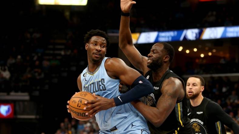 Mar 18, 2023; Memphis, Tennessee, USA; Memphis Grizzlies forward Jaren Jackson Jr. (13) spins toward the basket as Golden State Warriors forward Draymond Green (23) defends during the first half at FedExForum. Mandatory Credit: Petre Thomas-USA TODAY Sports