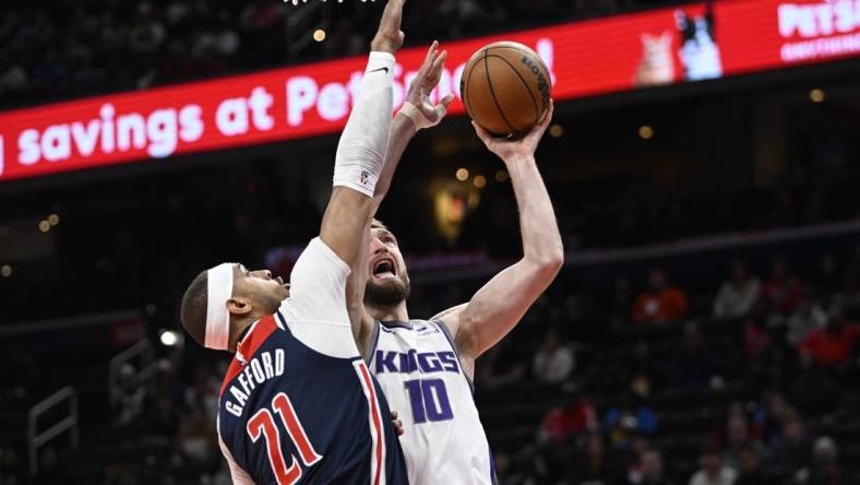 Mar 18, 2023; Washington, District of Columbia, USA; Sacramento Kings forward Domantas Sabonis (10) shoots over Washington Wizards center Daniel Gafford (21) during the first half at Capital One Arena. Mandatory Credit: Brad Mills-USA TODAY Sports