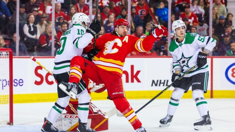 Mar 18, 2023; Calgary, Alberta, CAN; Calgary Flames defenseman Chris Tanev (8) and Dallas Stars center Ty Dellandrea (10) battle for the puck in front of Calgary Flames goaltender Jacob Markstrom (25) during the first period at Scotiabank Saddledome. Mandatory Credit: Sergei Belski-USA TODAY Sports