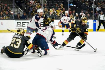 Mar 19, 2023; Las Vegas, Nevada, USA; Vegas Golden Knights center Chandler Stephenson (20) skates with the puck against Columbus Blue Jackets center Jack Roslovic (96) and defenseman Andrew Peeke (2) during the first period at T-Mobile Arena. Mandatory Credit: Lucas Peltier-USA TODAY Sports