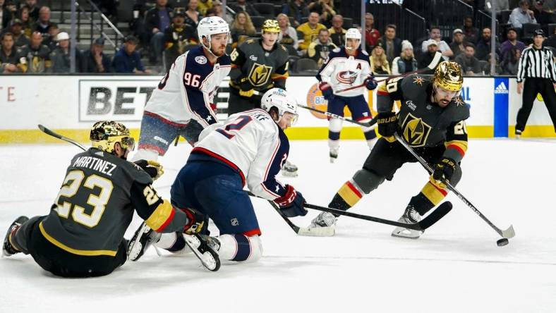 Mar 19, 2023; Las Vegas, Nevada, USA; Vegas Golden Knights center Chandler Stephenson (20) skates with the puck against Columbus Blue Jackets center Jack Roslovic (96) and defenseman Andrew Peeke (2) during the first period at T-Mobile Arena. Mandatory Credit: Lucas Peltier-USA TODAY Sports