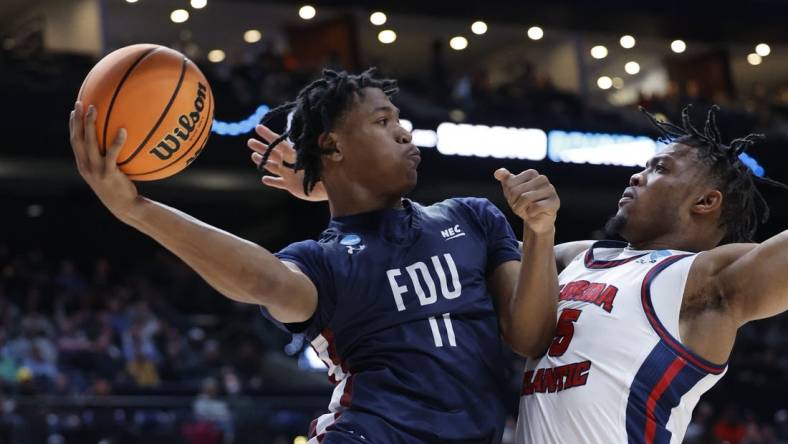 Mar 19, 2023; Columbus, OH, USA; Fairleigh Dickinson Knights forward Sean Moore (11) looks tot play the ball defended by Florida Atlantic Owls guard Bryan Greenlee (4) in the first half at Nationwide Arena. Mandatory Credit: Rick Osentoski-USA TODAY Sports