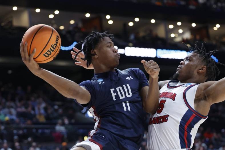 Mar 19, 2023; Columbus, OH, USA; Fairleigh Dickinson Knights forward Sean Moore (11) looks tot play the ball defended by Florida Atlantic Owls guard Bryan Greenlee (4) in the first half at Nationwide Arena. Mandatory Credit: Rick Osentoski-USA TODAY Sports