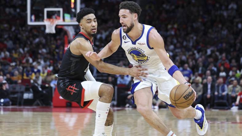 Mar 20, 2023; Houston, Texas, USA; Golden State Warriors guard Klay Thompson (11) drives with the ball as Houston Rockets forward KJ Martin (6) defends during the second quarter at Toyota Center. Mandatory Credit: Troy Taormina-USA TODAY Sports