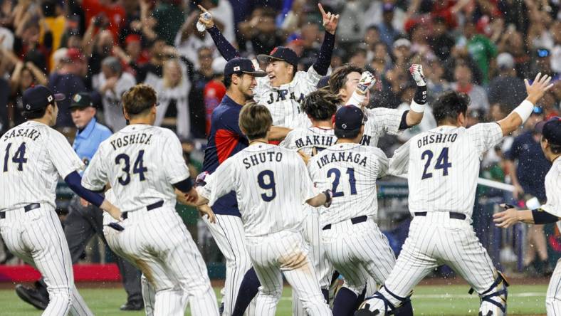 Mar 20, 2023; Miami, Florida, USA; Team Japan celebrates on the field after winning the game with a walk-off double from Japan third baseman Munetaka Murakami (55) during the ninth inning against Mexico at LoanDepot Park. Mandatory Credit: Sam Navarro-USA TODAY Sports