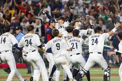 Mar 20, 2023; Miami, Florida, USA; Team Japan celebrates on the field after winning the game with a walk-off double from Japan third baseman Munetaka Murakami (55) during the ninth inning against Mexico at LoanDepot Park. Mandatory Credit: Sam Navarro-USA TODAY Sports