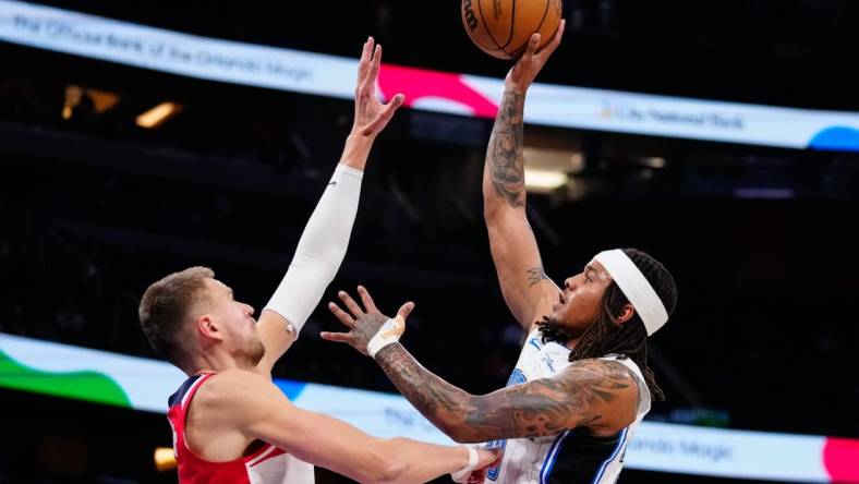 Mar 21, 2023; Orlando, Florida, USA; Orlando Magic guard Markelle Fultz (20) shoots over Washington Wizards center Kristaps Porzingis (6) during the first quarter at Amway Center. Mandatory Credit: Rich Storry-USA TODAY Sports