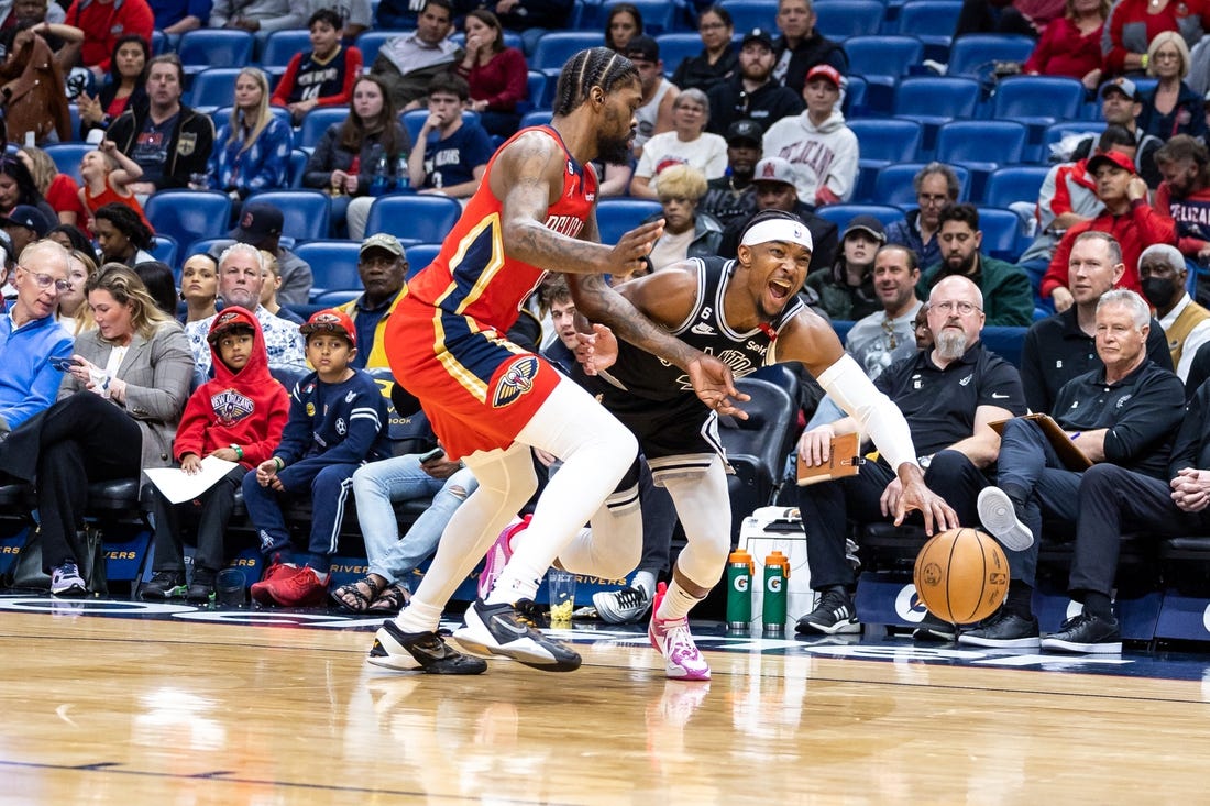 Mar 21, 2023; New Orleans, Louisiana, USA;  San Antonio Spurs guard Devonte' Graham (4) dribbles against New Orleans Pelicans forward Naji Marshall (8) during the first half at Smoothie King Center. Mandatory Credit: Stephen Lew-USA TODAY Sports