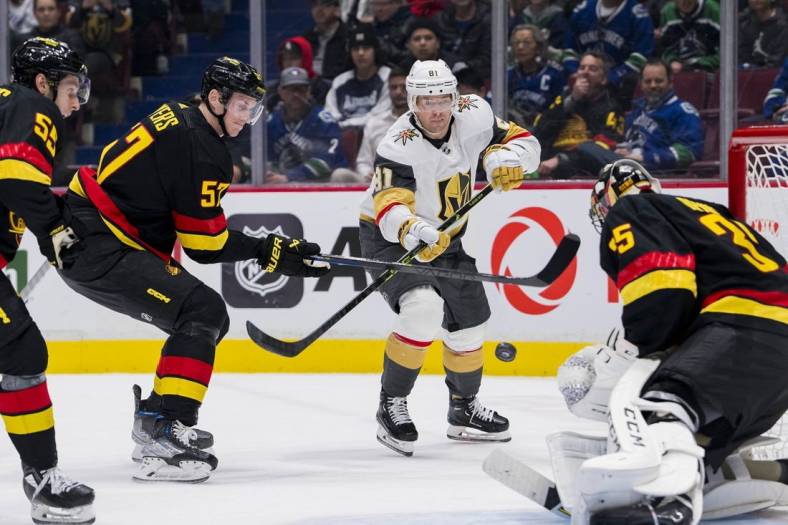 Mar 21, 2023; Vancouver, British Columbia, CAN; Vancouver Canucks defenseman Guillaume Brisebois (55) and defenseman Tyler Myers (57) watch as Vegas Golden Knights forward Jonathan Marchessault (81) shoots on goalie Thatcher Demko (35) in the second period at Rogers Arena. Mandatory Credit: Bob Frid-USA TODAY Sports