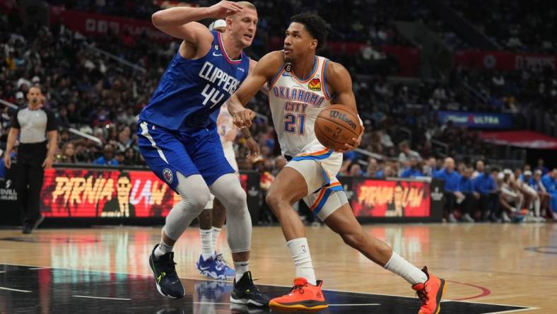 Mar 21, 2023; Los Angeles, California, USA; Oklahoma City Thunder guard Aaron Wiggins (21) dribbles the ball against LA Clippers center Mason Plumlee (44) in the second half at Crypto.com Arena. Mandatory Credit: Kirby Lee-USA TODAY Sports