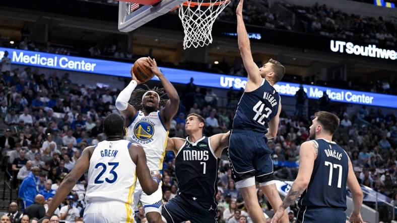 Mar 22, 2023; Dallas, Texas, USA; Golden State Warriors forward Kevon Looney (5) shoots over Dallas Mavericks center Dwight Powell (7) and forward Maxi Kleber (42) and guard Luka Doncic (77) during the first quarter at the American Airlines Center. Mandatory Credit: Jerome Miron-USA TODAY Sports