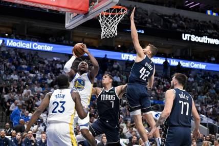 Mar 22, 2023; Dallas, Texas, USA; Golden State Warriors forward Kevon Looney (5) shoots over Dallas Mavericks center Dwight Powell (7) and forward Maxi Kleber (42) and guard Luka Doncic (77) during the first quarter at the American Airlines Center. Mandatory Credit: Jerome Miron-USA TODAY Sports