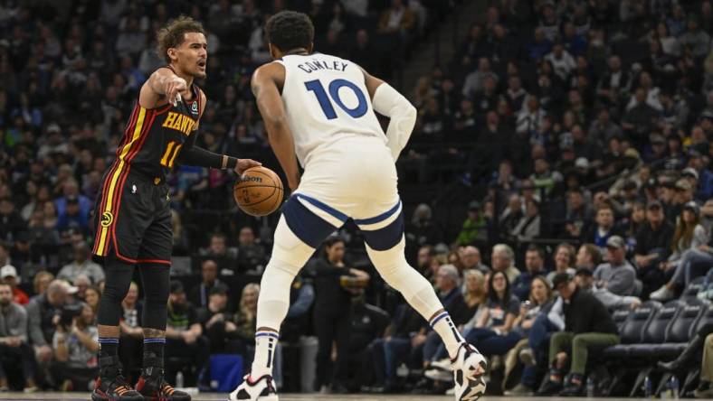 Mar 22, 2023; Minneapolis, Minnesota, USA;  Atlanta Hawks guard Trae Young (11) calls a play as Minnesota Timberwolves guard Mike Conley (10) defends in the second quarter at Target Center. Mandatory Credit: Nick Wosika-USA TODAY Sports