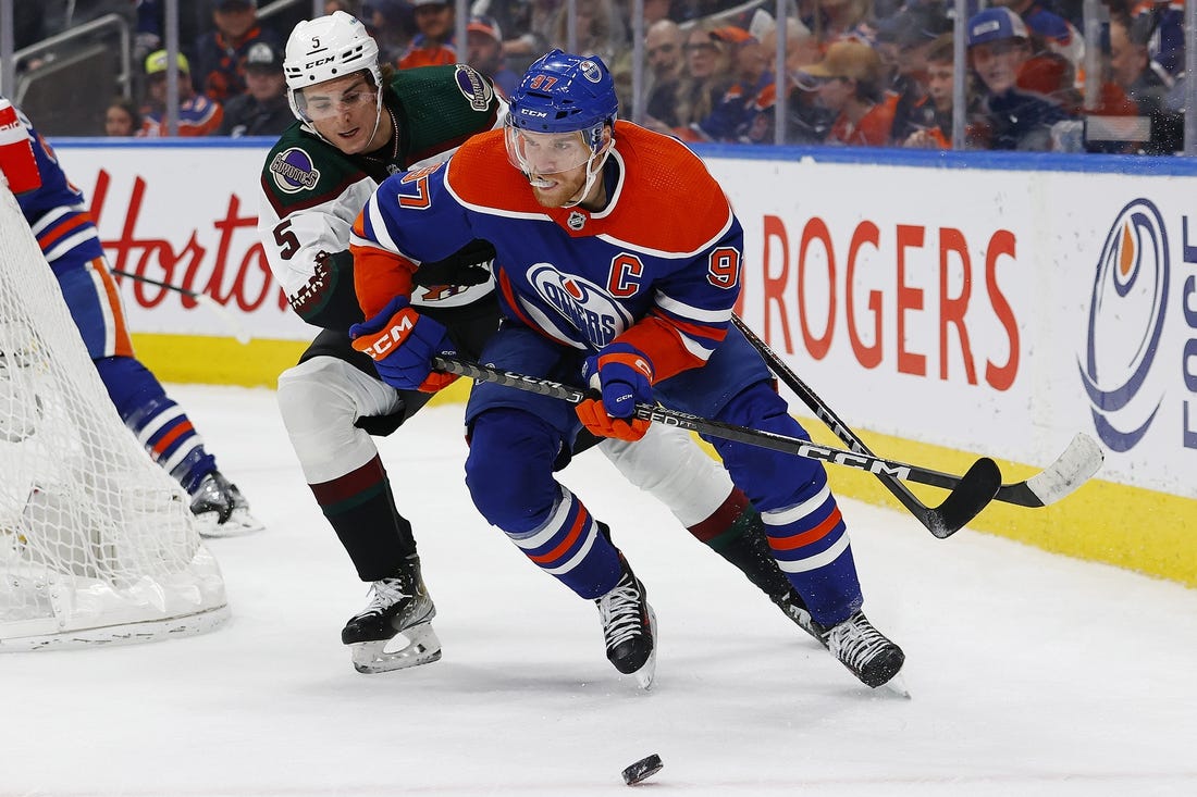 Mar 22, 2023; Edmonton, Alberta, CAN; Edmonton Oilers forward Connor McDavid (97) protects the puck from Arizona Coyotes defensemen Michael Kesselring (5) during the first period at Rogers Place. Mandatory Credit: Perry Nelson-USA TODAY Sports