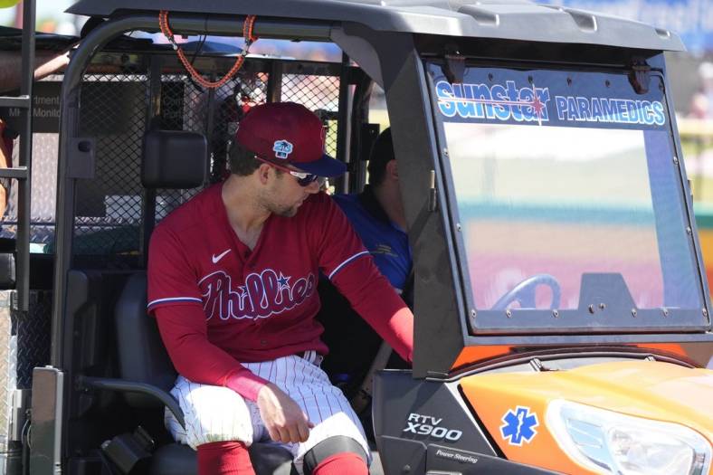 Mar 23, 2023; Clearwater, Florida, USA; Philadelphia Phillies first baseman Rhys Hoskins (17) leaves the game on a medical cart after falling to the ground while trying to field a ball during the first inning at BayCare Ballpark. Hoskins was injured during the play and left the game. Mandatory Credit: Dave Nelson-USA TODAY Sports