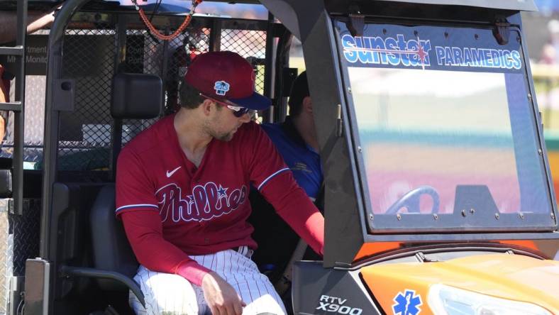 Mar 23, 2023; Clearwater, Florida, USA; Philadelphia Phillies first baseman Rhys Hoskins (17) leaves the game on a medical cart after falling to the ground while trying to field a ball during the first inning at BayCare Ballpark. Hoskins was injured during the play and left the game. Mandatory Credit: Dave Nelson-USA TODAY Sports