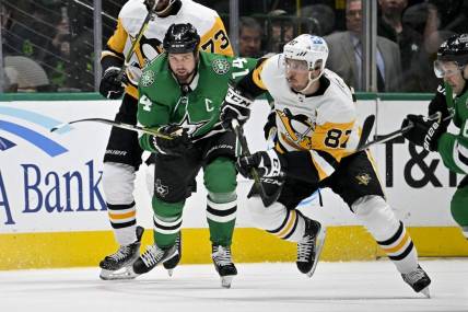 Mar 23, 2023; Dallas, Texas, USA; Dallas Stars left wing Jamie Benn (14) and Pittsburgh Penguins center Sidney Crosby (87) chase the puck during the second period at the American Airlines Center. Mandatory Credit: Jerome Miron-USA TODAY Sports