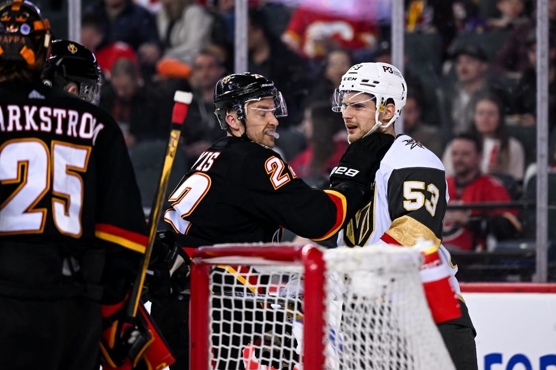 Mar 23, 2023; Calgary, Alberta, CAN; Calgary Flames center Trevor Lewis (22) grabs Vegas Golden Knights center Teddy Blueger (53) after a whistle during the second period at Scotiabank Saddledome. Mandatory Credit: Brett Holmes-USA TODAY Sports