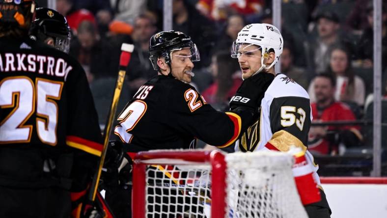 Mar 23, 2023; Calgary, Alberta, CAN; Calgary Flames center Trevor Lewis (22) grabs Vegas Golden Knights center Teddy Blueger (53) after a whistle during the second period at Scotiabank Saddledome. Mandatory Credit: Brett Holmes-USA TODAY Sports