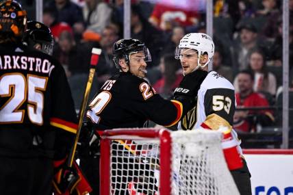Mar 23, 2023; Calgary, Alberta, CAN; Calgary Flames center Trevor Lewis (22) grabs Vegas Golden Knights center Teddy Blueger (53) after a whistle during the second period at Scotiabank Saddledome. Mandatory Credit: Brett Holmes-USA TODAY Sports